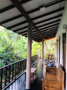 a balcony of a house with benches and trees at Sh li in Sigiriya