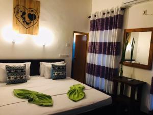 a bedroom with a bed with green towels on it at Sh li in Sigiriya