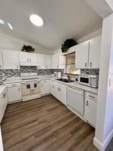 a large white kitchen with white cabinets and appliances at Perfect lodging in Lake Placid in Lake Placid