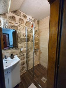 une salle de bain avec douche et lavabo dans l'établissement Little Bay Apartments, à Kotor