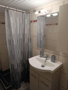 Un baño con lavabo y cortina de ducha. en Nikos apartment (center of Kavala), en Kavala