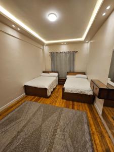 a small room with two beds and a television at شقة بوسط المدينة الدقي in Cairo