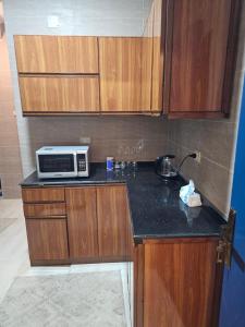 a kitchen with wooden cabinets and a microwave on a counter at شقة بوسط المدينة الدقي in Cairo