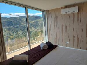 a bedroom with a bed with a large window at Casas do Bau in Vieira do Minho +47 photos