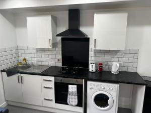 una cocina con estufa y lavadora en Leicester Haven near Train Station, en Leicester 1 foto más