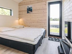 a bedroom with a bed and a large window at 9 person holiday home in Væggerløse-By Traum in Marielyst +33 photos