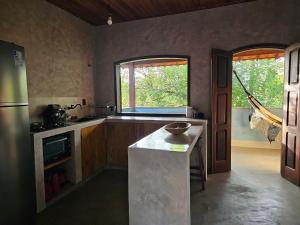a kitchen with a counter and a large window at Casa de Lux in Ilha de Boipeba +19 photos