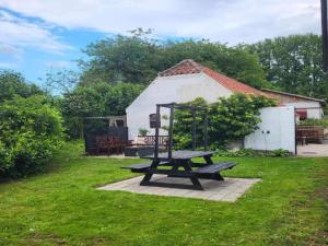 a picnic table in the grass in front of a building at Lysbjerggård in Faaborg +6 photos