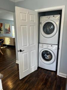 a washer and dryer in a room with a door at Historic Belmont Home - Steps to Stowe Manor and Downtown in Belmont