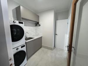 a kitchen with a washer and dryer and a sink at Allure Beach House - Formerly Sands on Moreton in Tangalooma