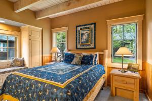 ein Schlafzimmer mit einem Bett und zwei Fenstern in der Unterkunft Metolius Cabin 7 in Camp Sherman