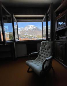 a chair in a room with a view of a mountain at Sogni di Montagna -Campitello Matese in San Massimo