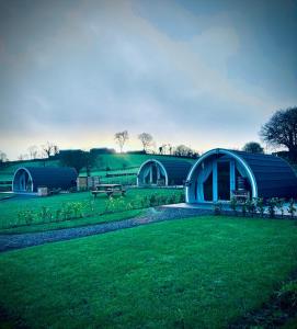 a blue building in the middle of a green field at Knockmany View Glamping in Augher