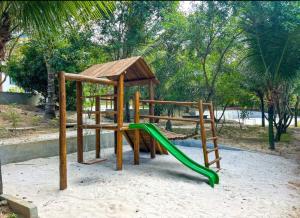 a playground with a green slide and a gazebo at Casa na Reserva Sapiranga, Praia do Forte in Mata de Sao Joao