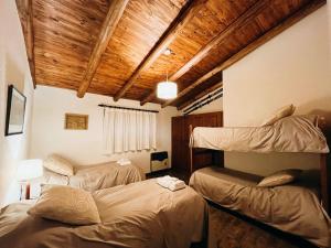 two bunk beds in a room with wooden ceilings at Casa Pradera de los Andes in Tupungato