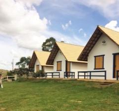 duży biały dom z trawnikiem w obiekcie Pousada Serra Azul w mieście Tiradentes