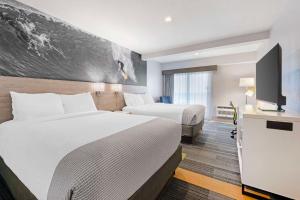 a hotel room with two beds and a flat screen tv at Best Western Oceanfront in Jacksonville Beach +30 photos