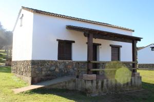 エル・カスティージョ・デ・ラス・グアルダスにあるAlojamiento Rural 'al Muniat'の石壁の白い小さな建物