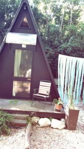 a tent with a bench and a chair on a porch at Forest Glam in San Andrés de Giles