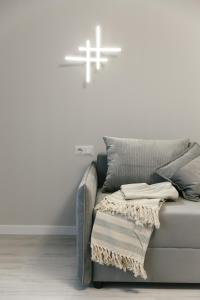 a white cross on the wall above a couch at GrandStay downtown Suites - 3 Modern 2BD Apartments in Central Chișinău in Chişinău +33 photos