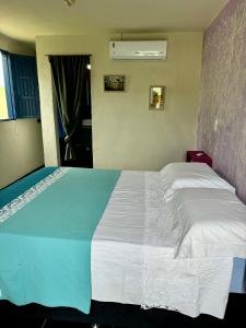 a bedroom with a large bed with white sheets at Casa Tô na Onda in Prado