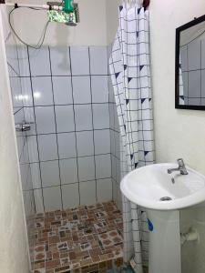 une salle de bain avec lavabo et douche dans l'établissement Hotel Posada San Jose, à Malacatán