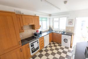 a kitchen with wooden cabinets and a checkered floor at The Marion Plas in Prestatyn