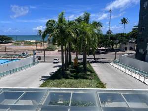 a view of a street with palm trees and the ocean at Frente Mar - Beach Class Internacional - Flat Boa Viagem in Recife