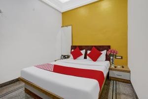 a bedroom with a large bed with red pillows at Hotel O Chhaya in Aurangabad