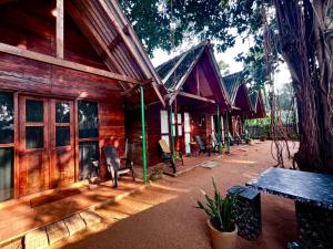 una casa di legno con una panchina di fronte di Cool Banyan Cabana a Trincomalee