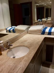 a bathroom counter with a sink and two mirrors at Mayan Vidanta departamento 2 recámaras CON SERVICIO DE PLAYA in Acapulco