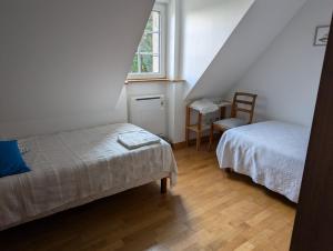 a bedroom with two beds and a window and a chair at Maison d'hôtes "Bienlivien" in Saint-Coulomb