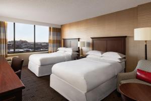 a hotel room with two beds and a chair at Sheraton Philadelphia University City Hotel in Philadelphia