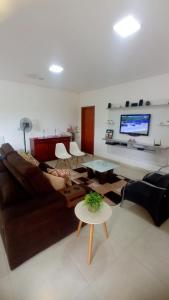 a living room with a couch and a tv at Pousada Paraíso das Águas Capitólio in Capitólio