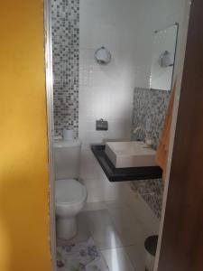 a small bathroom with a toilet and a sink at Newen Hospedagem in Arraial do Cabo +43 photos