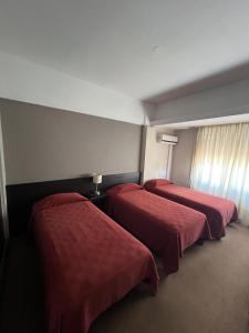 サン・フランシスコにあるAires del libertadorのベッド2台 ホテルルーム 赤いシーツ付 +2枚の写真