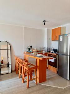 a kitchen with a wooden table and a refrigerator at Desconexión y Paz in Pucón +5 photos