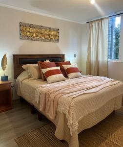a bedroom with a large bed with pillows at Desconexión y Paz in Pucón