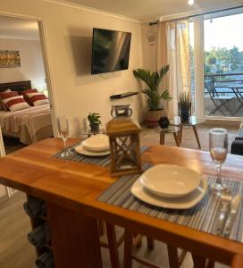 a living room with a table with plates and wine glasses at Desconexión y Paz in Pucón +5 photos