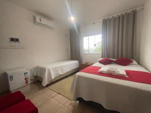 a bedroom with two beds and a window at Casa Paraíso das Águas in Capitólio +14 photos