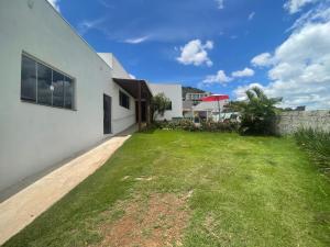 an empty yard next to a white building at Casa Paraíso das Águas in Capitólio