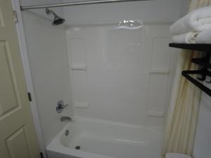 een douche in de badkamer met witte handdoeken op een plank bij Americourt Hotel and Suites - Elizabethton in Elizabethton