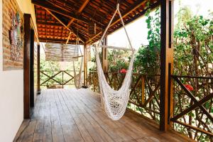 a hammock on the porch of a house at Casa Bem Te Vi in Amontada