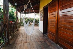 a hammock hangs from the porch of a house at Casa Bem Te Vi in Amontada