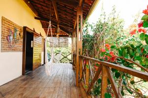 a wooden porch of a house with flowers at Casa Bem Te Vi in Amontada