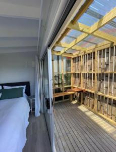 a bedroom with a bed and a large window at Studio at Otama Beach in Opito Bay