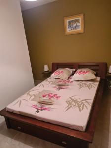 una camera da letto con un letto con fiori rosa di Villa Kasanaco avec vue sur la mer a Case-Pilote Altre 7 foto