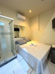 a bedroom with two beds and a glass shower at Cine Rio Hostel RJ in Rio de Janeiro