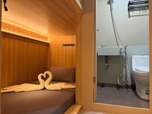 a bathroom with a bed with a towel animal on it at Dosare Capsule Hotel in Yogyakarta