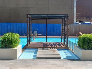 a pool with a wooden bridge over a swimming pool at Mike's Residence at Marina Spatial - Dumaguete City in Piapi